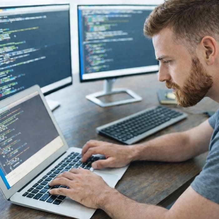 Desenvolvedor criando aplicação web personalizada para software sob demanda em ambiente de programação