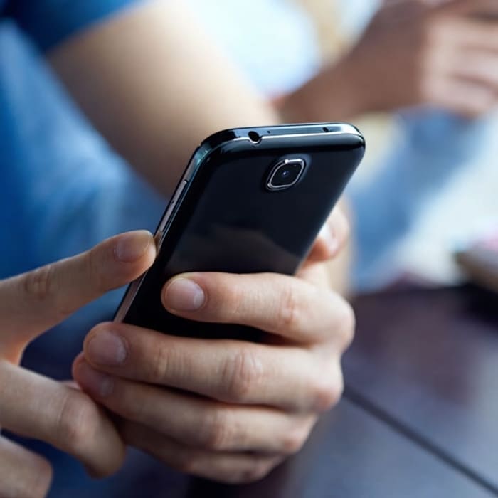 Pessoa utilizando smartphone, representando desenvolvimento de aplicativos mobile personalizados para empresas e sistemas sob demanda